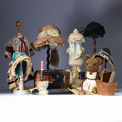 Ensemble de divers accessoires de poupée, habits, coiffes et jeux d'enfants incluant une petite machine à coudre en tôle.