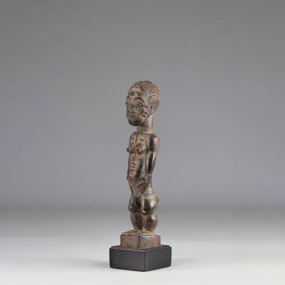 Baoulé statuette-Old female Baoulé statuette (Ivory Coast). Very beautiful sculpture, refined, adorned with projecting cut scarifications. Shiny black patina. Imprint of a missing fabric
