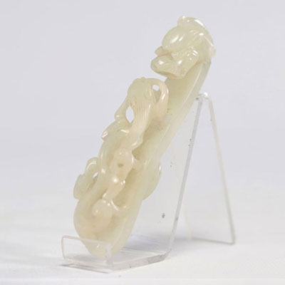 White jade fibula in the shape of a dragon looking at a Chilon