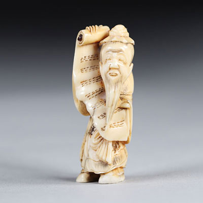 Netsuke carved - a sage carrying a sheet music. Japan Meiji period around 1900