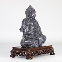 Bouddha en pierre sur un socle en bois