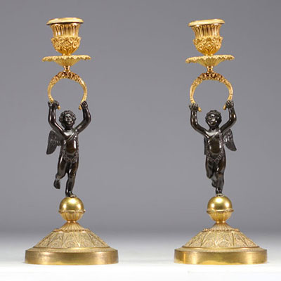 (2) Paire de bougeoirs en bronze à deux patines à décor d'angelots d'époque Empire.