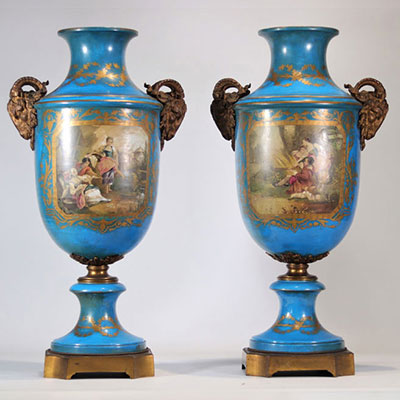 Pair of monumental Sèvres porcelain vases decorated with bronze rams' heads and with romantic scenes on a blue background
