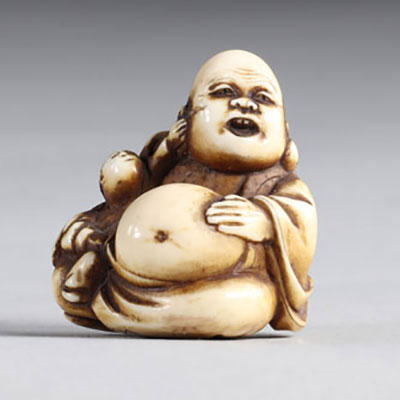 Netsuke sculpté d'un bouddha et d'un enfant tirant son oreille. Japon époque Meiji 19ème