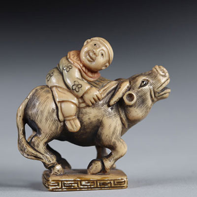 Netsuke carved - a character on a buffalo. Japan early 20th century