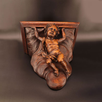 Carved wooden wall lamp decorated with a cherub