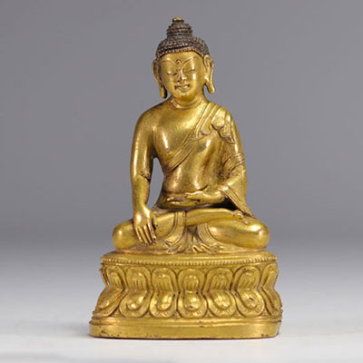 Sculpture d'un bouddha assit sur un socle en bronze doré