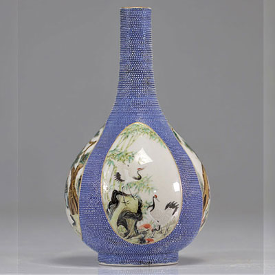 Vase en porcelaine de chine scènes peintes en cartouches sur fond bleu