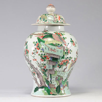 Covered porcelain vase of the green family decorated with birds and has a mark in the form of circles
