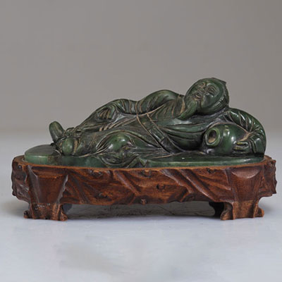 Carved spinach jade reclining figure from Qing period