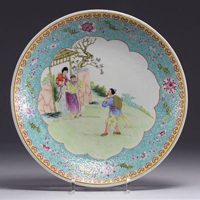 Chine - Assiette en porcelaine famille rose à décor de personnages au jardin, époque République.