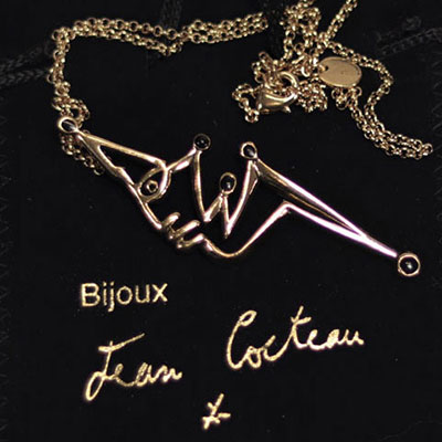 Jean Cocteau. Pendentif en métal doré et émail noir. Signé 