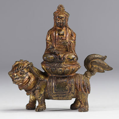 Sculpture Guanine en bronze doré reposant sur un lion de l'époque Qing (清朝)