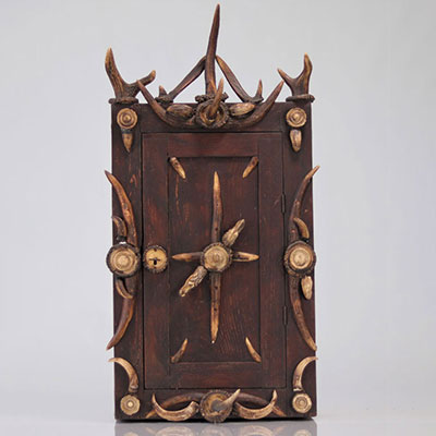 Hunting cabinet decorated with carved antlers dog and horse head