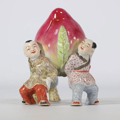 Famille rose porcelain sculpture showing young children holding a large peach