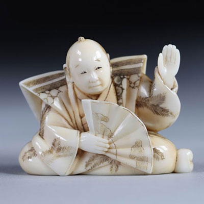 Netsuke carved - a character - a fan. Japan Meiji period around 1900