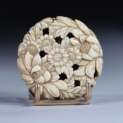 Netsuke Manju circulaire sculpté de fleurs. Japon époque Meiji vers 1900
