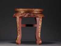 Chine - Petite table d'appoint en laque rouge er or à décor sculpté de personnages et de motifs floraux, fin XIXe siècle.