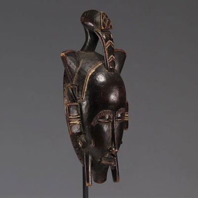 Masque de danse Kpelié surmonté d'une tête d'oiseau, peuple Sénoufo, Côte d'Ivoire, bois à patine noire.