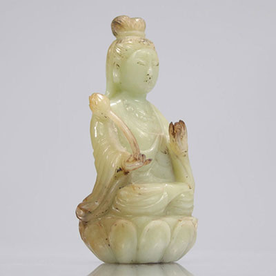 Guanyin in celadon green jade seated on a Qing period lotus flower