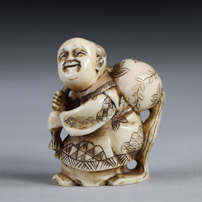 Netsuke carved - a figure carrying a sack. Japan Meiji period around 1900