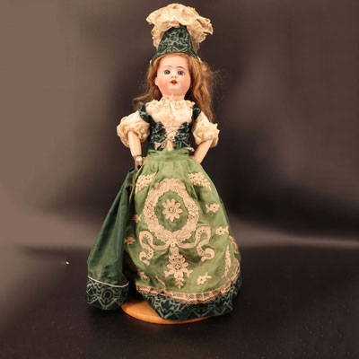 Large doll head in porcelain green dress