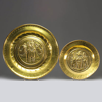 Set of two embossed and repoussé brass offering dishes decorated with religious scenes.