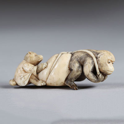 Netsuke sculpté d'un singe qui tire un sac et un ourson. Japon époque Meiji vers 1900