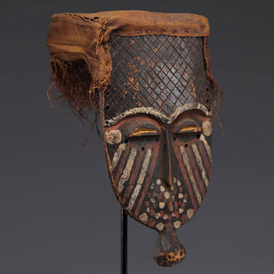 Flat mask, Lélé, DRC, wood with a patina of use, red pigments and white kaolin, fabric, raffia
