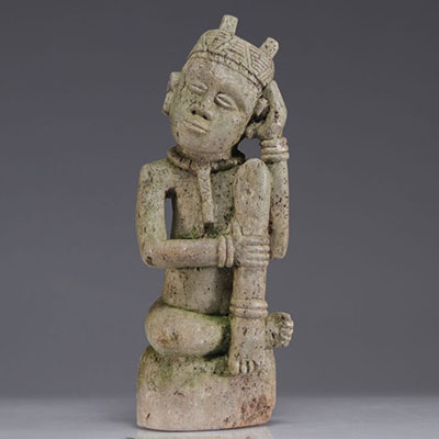 Statue Ntadi Congo en pierre, assis en tailleur avec une main tenue au visage, l'autre bras sur les hanches, collier sculpté