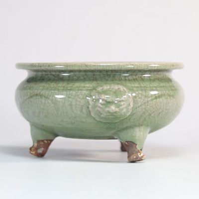 Celadon glazed stoneware perfume burner resting on three legs and decorated with lions' heads