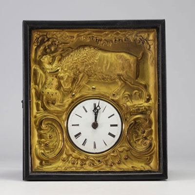 Wall clock in repoussé brass decorated with buffalos and panthers, 19th century.